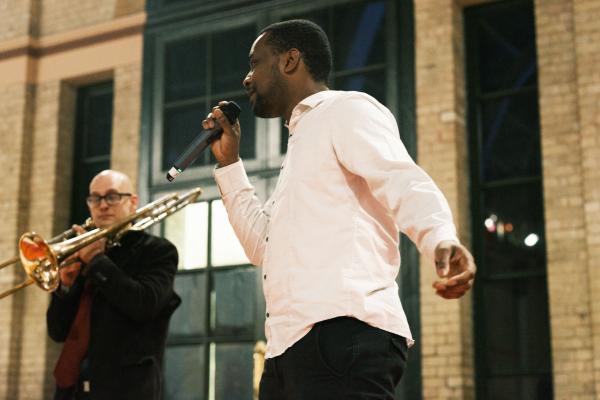 performance - 1 man singing another playing the trombone