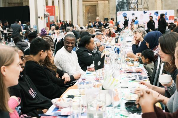 Smiling guests sitting at a large banqueting table 