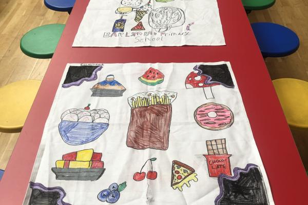 Primary school canteen table with hand decorated napkins on display